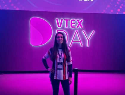 Ady com a logomarca do evento VTex Day atrás